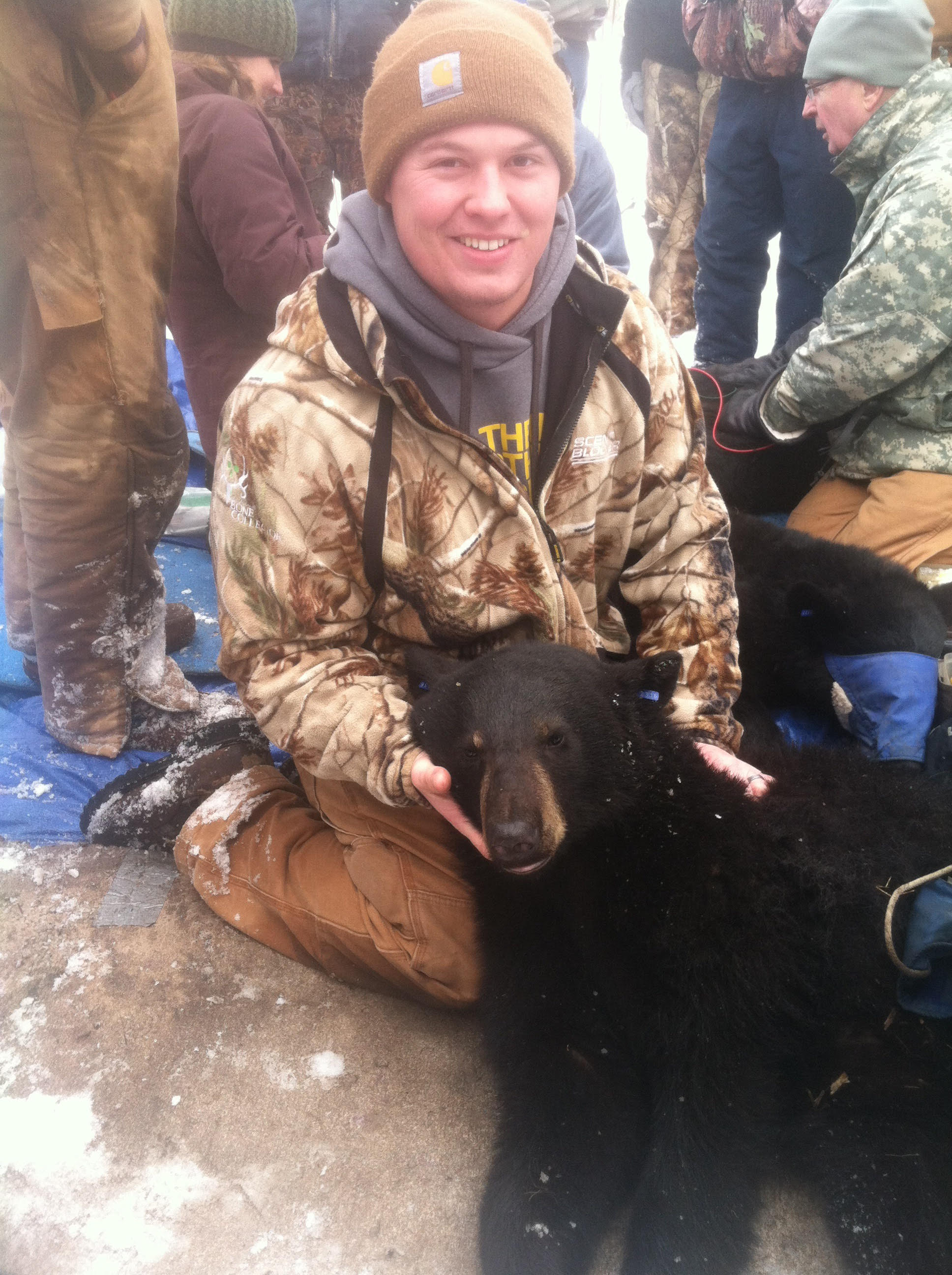 Photo of Dylan, supporting the head of a black bear